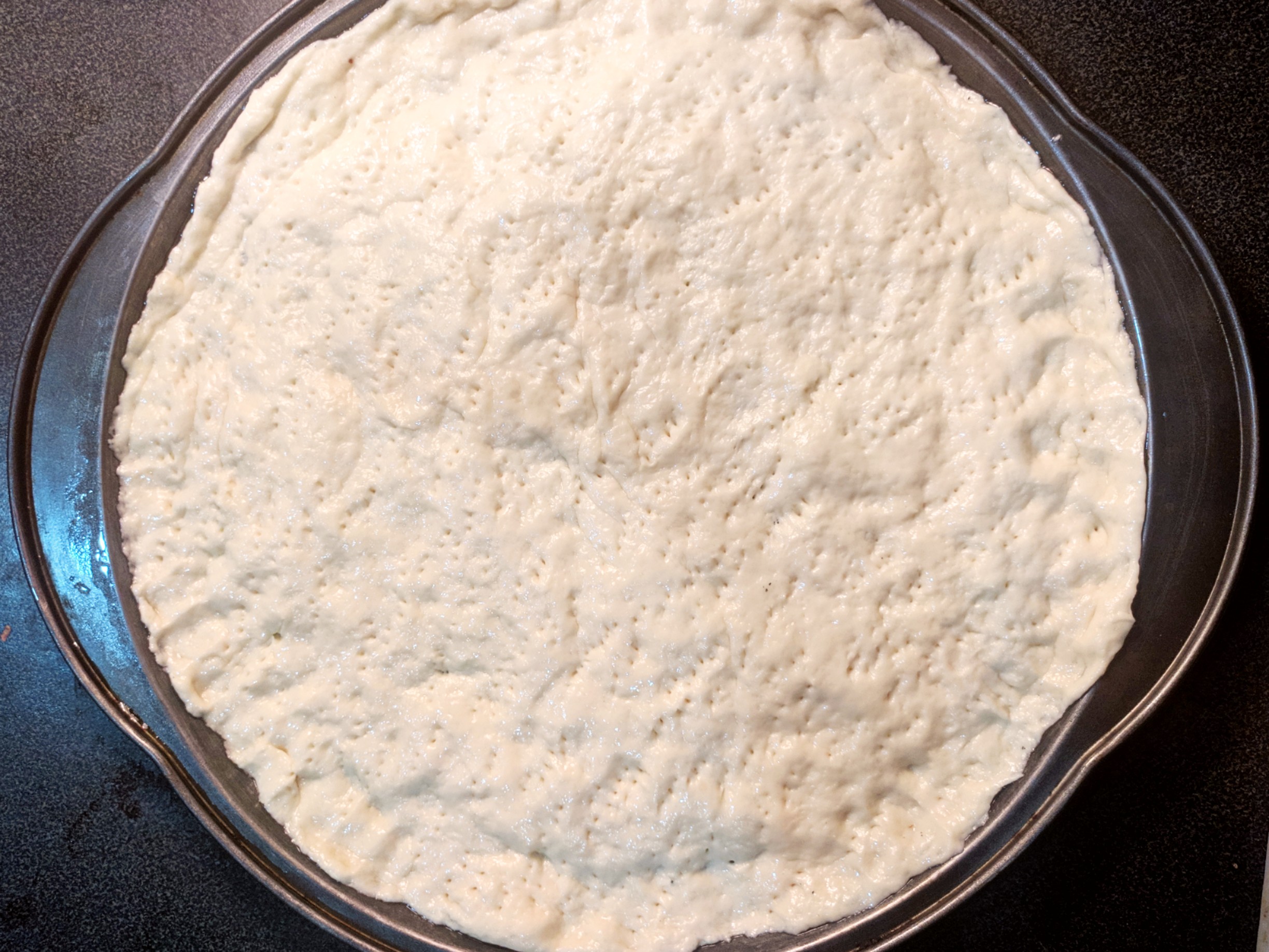 spreading pizza dough